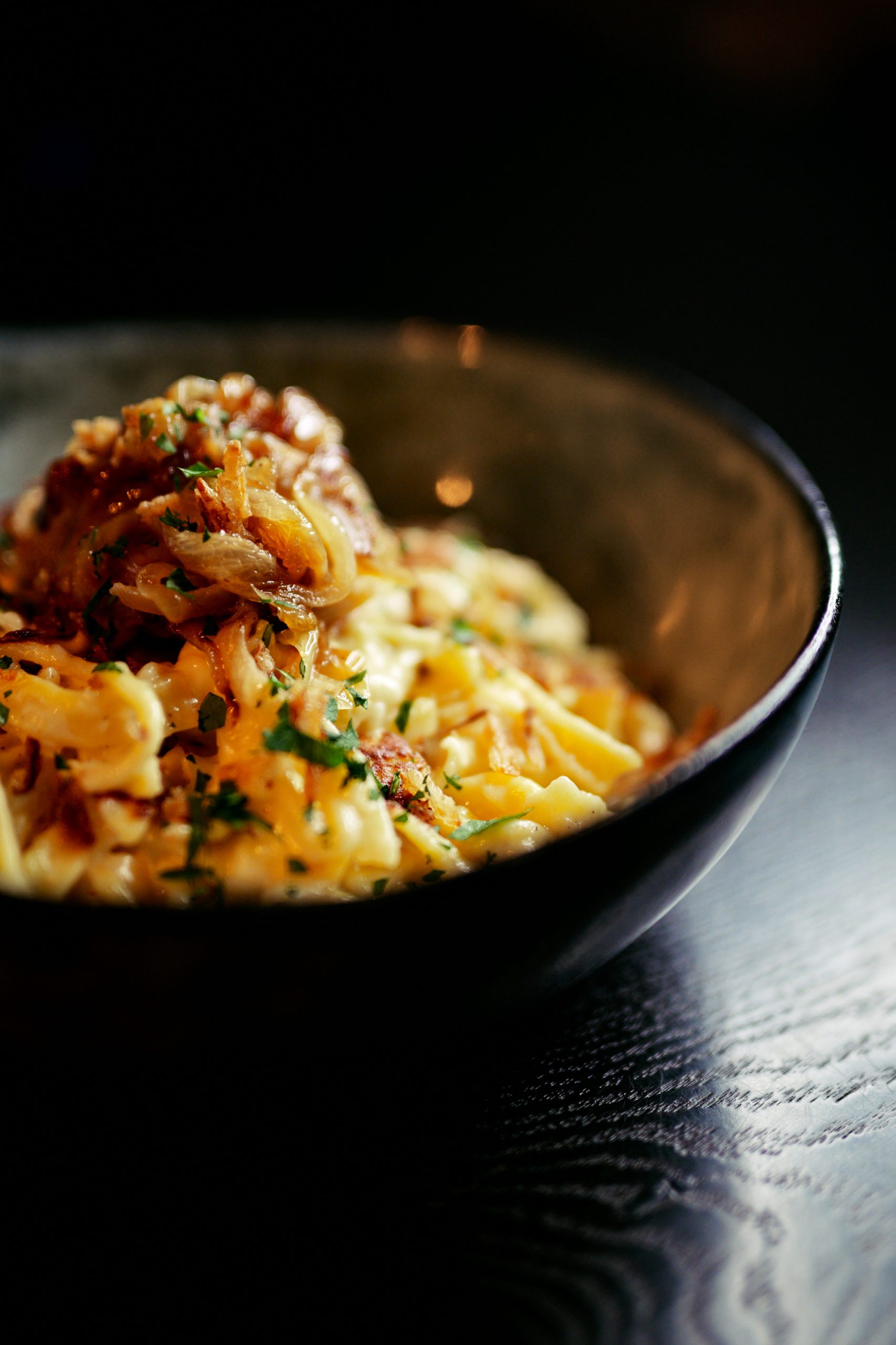 Schüssel mit Käsespätzle und Schmelzzwiebeln